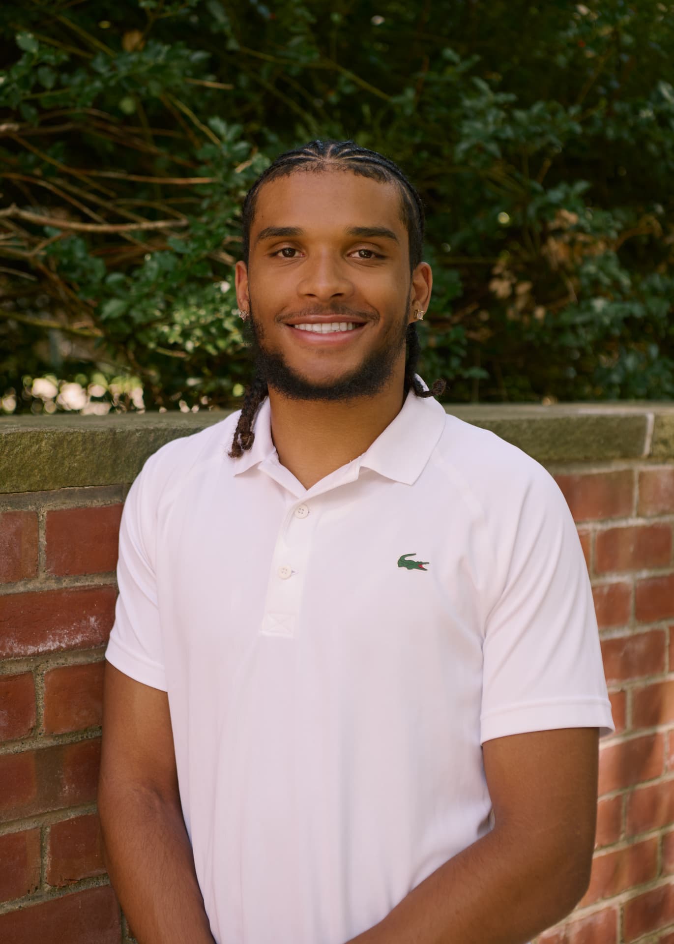 Jayden, founder of Clean Blocks, smiling in front of a brick wall
